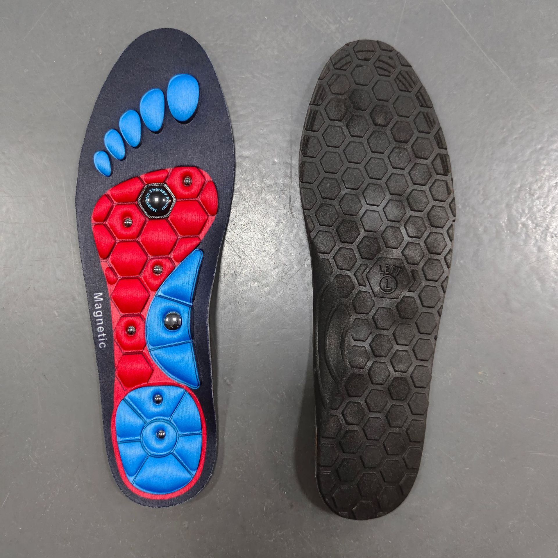 Insole with red and blue foot-shaped design on a gray surface