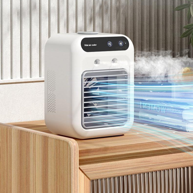 A compact white portable air conditioner fan with a touchscreen interface, emitting a cool mist, placed on a wooden surface.