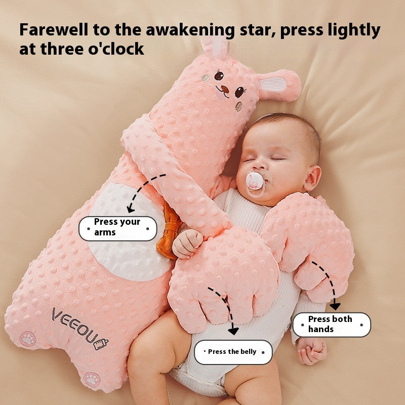 Baby lying on a pink plush toy with instructions on how to wake it up.