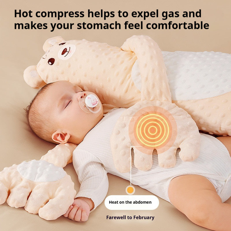 Baby lying on a plush toy with text about hot compresses for gas relief.