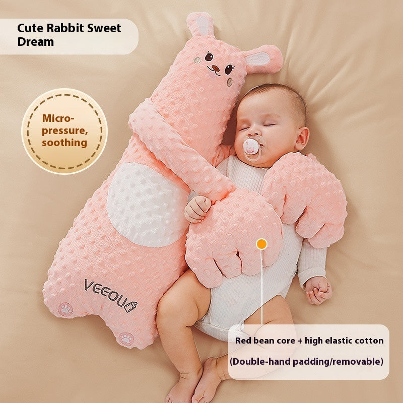 Baby sleeping with a pink rabbit-shaped comfort pillow on a beige background