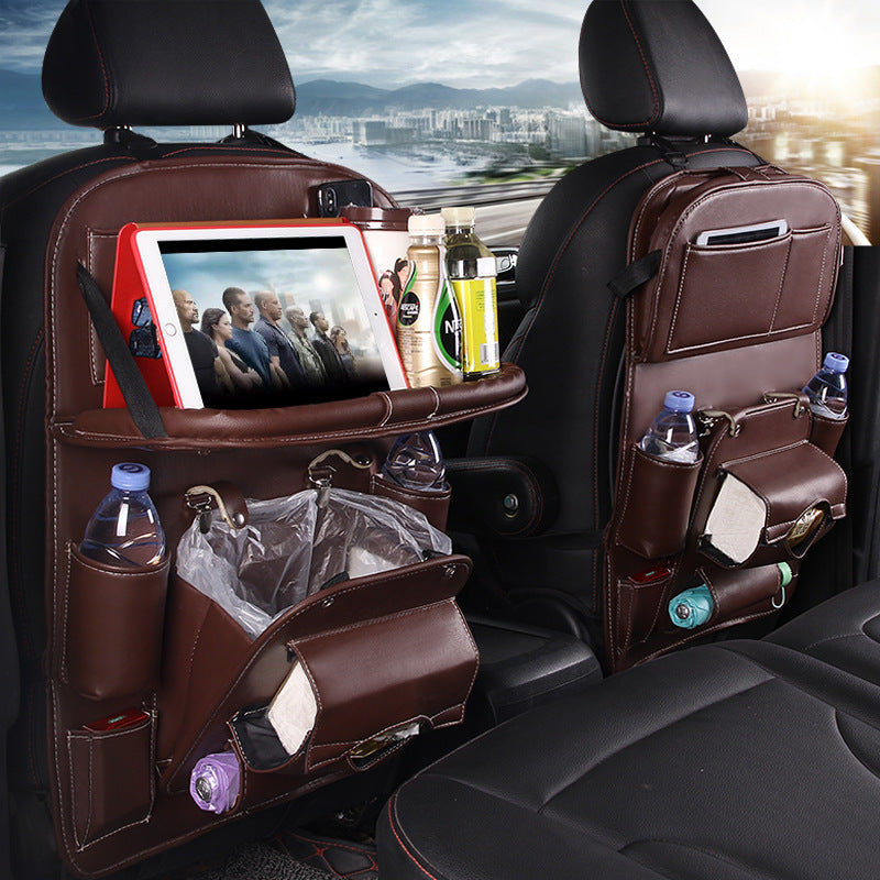 Car back seat organizer with multiple pockets and a tablet holder, set against a cityscape background.