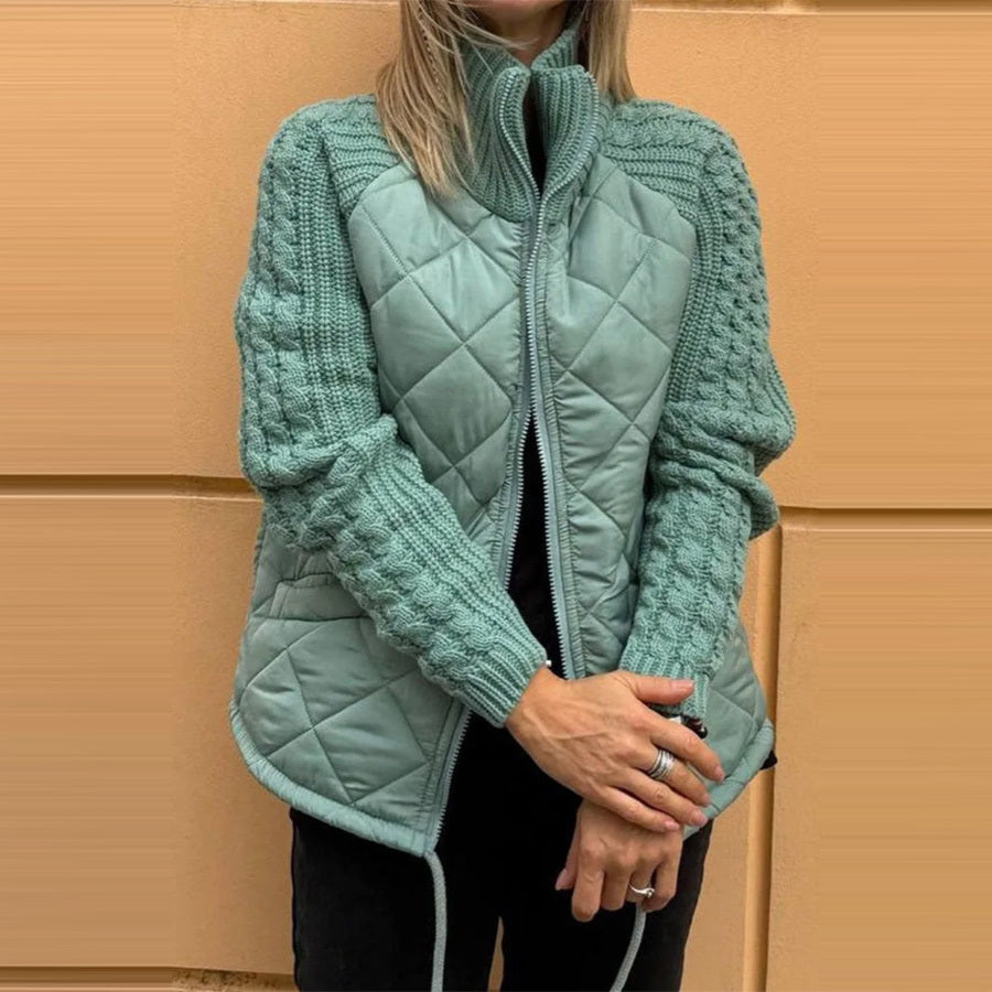 Teal quilted jacket worn by a person against a beige wall