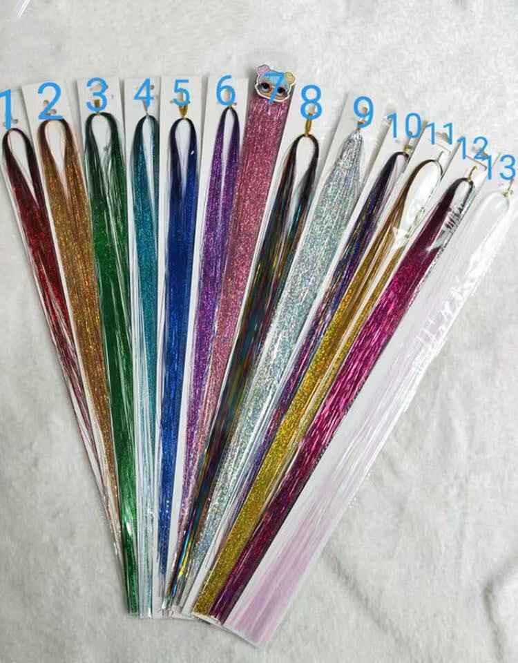 A collection of colorful laser hair color extensions displayed in a fan arrangement, including shades of red, green, blue, purple, and multicolor.