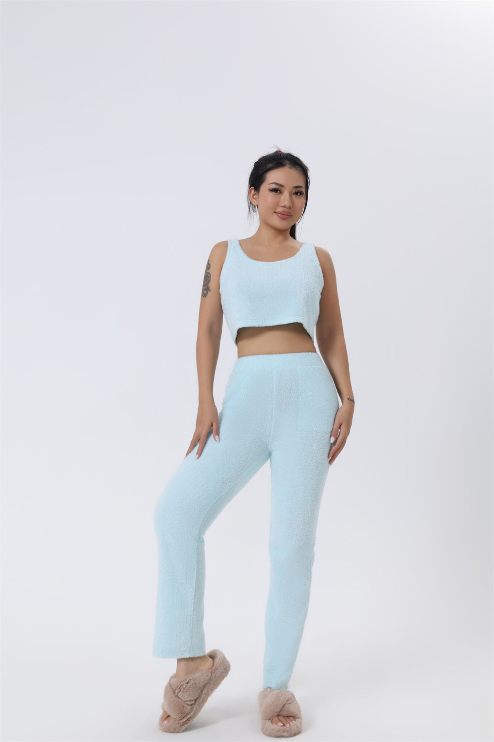 Woman wearing a light blue athletic outfit on a white background