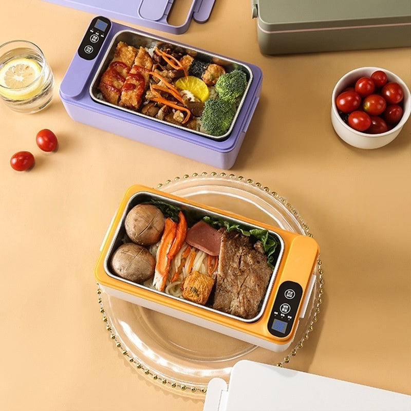 Two lunch boxes with food on a beige surface, surrounded by tomatoes and a glass of water.