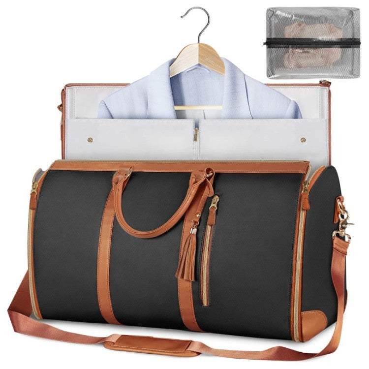 Black duffel bag with brown leather straps and trim, open to reveal a shirt on a hanger and a clear pouch.
