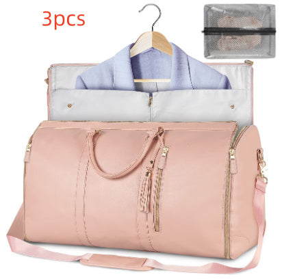 Pink duffel bag with clothing items and a hanger on a white background
