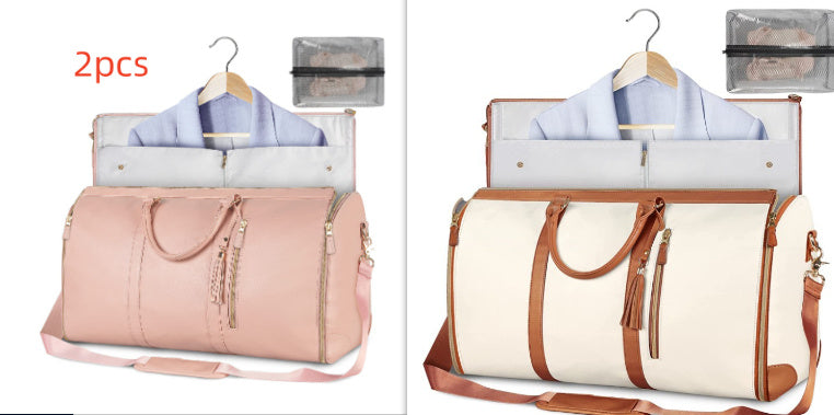 Pink and beige travel bags with clothes on hangers, on a white background.