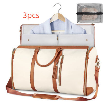 White travel bag with brown straps, clothes on a hanger, and a mesh pouch on a white background.