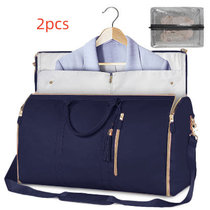 Navy blue travel bag with gold zippers, containing a shirt and a small mesh pouch on a white background.