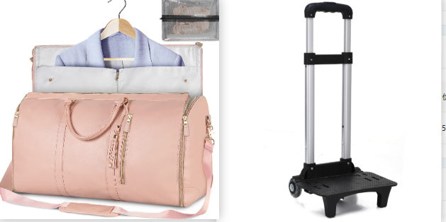 Pink duffel bag with clothes and a black rolling cart on a white background