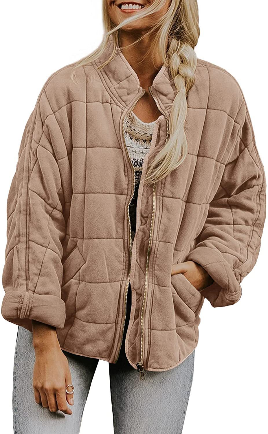 Woman wearing a quilted beige jacket on a white background