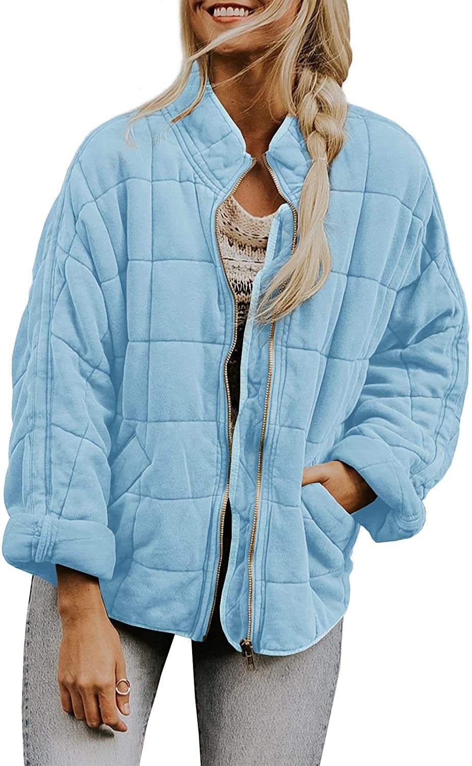 Woman wearing a light blue quilted jacket on a white background