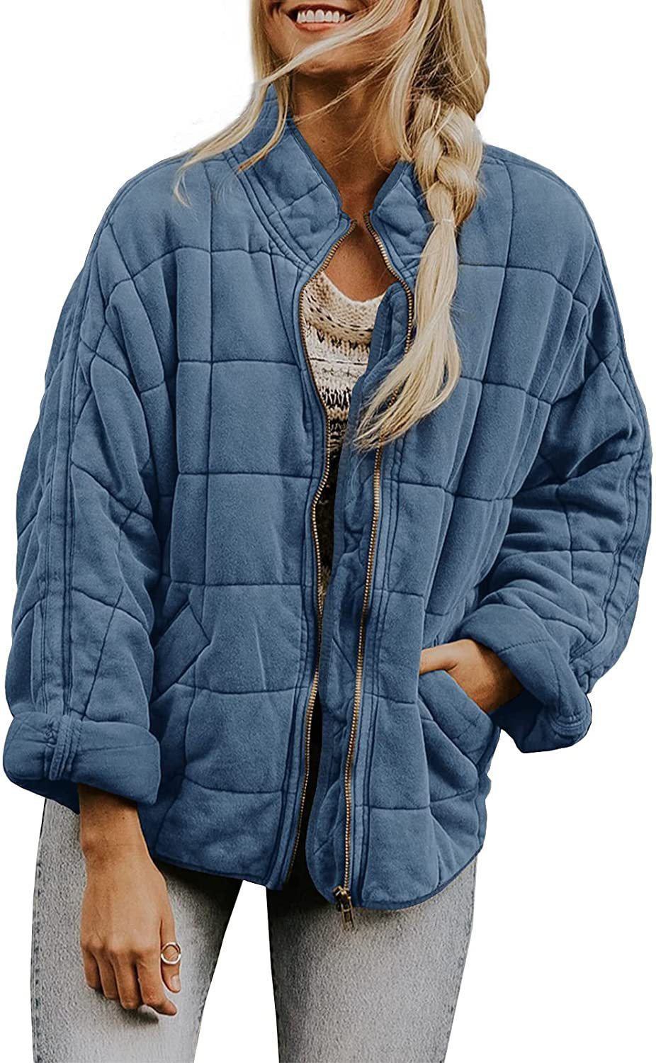 Woman wearing a blue quilted jacket on a white background