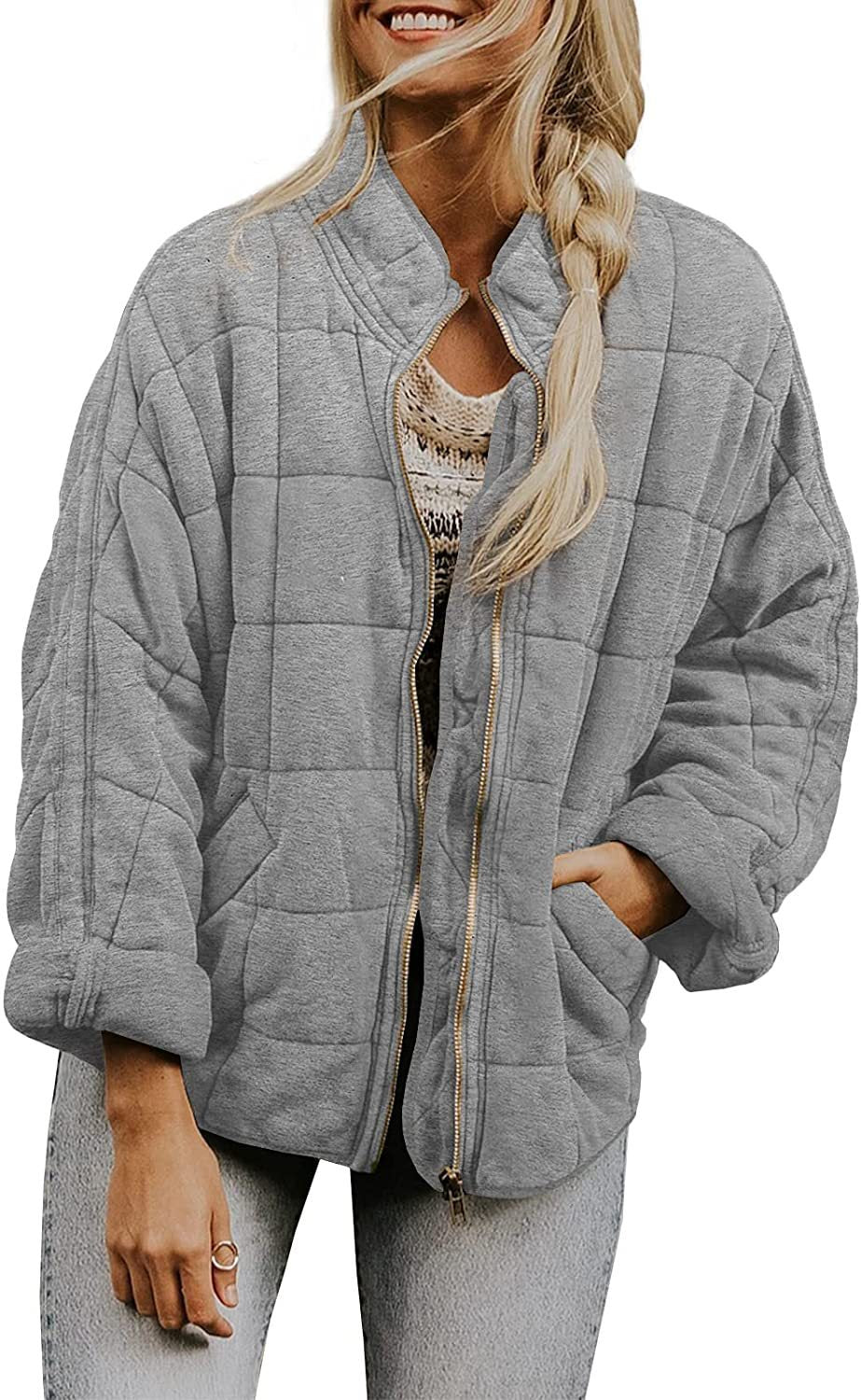 Woman wearing a gray quilted jacket on a white background