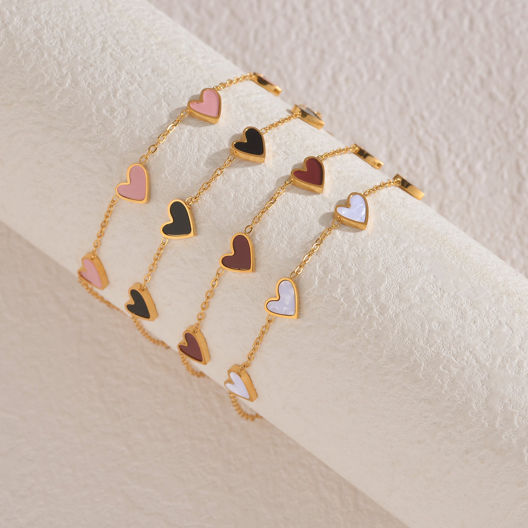 Bracelet with heart-shaped charms on a beige surface