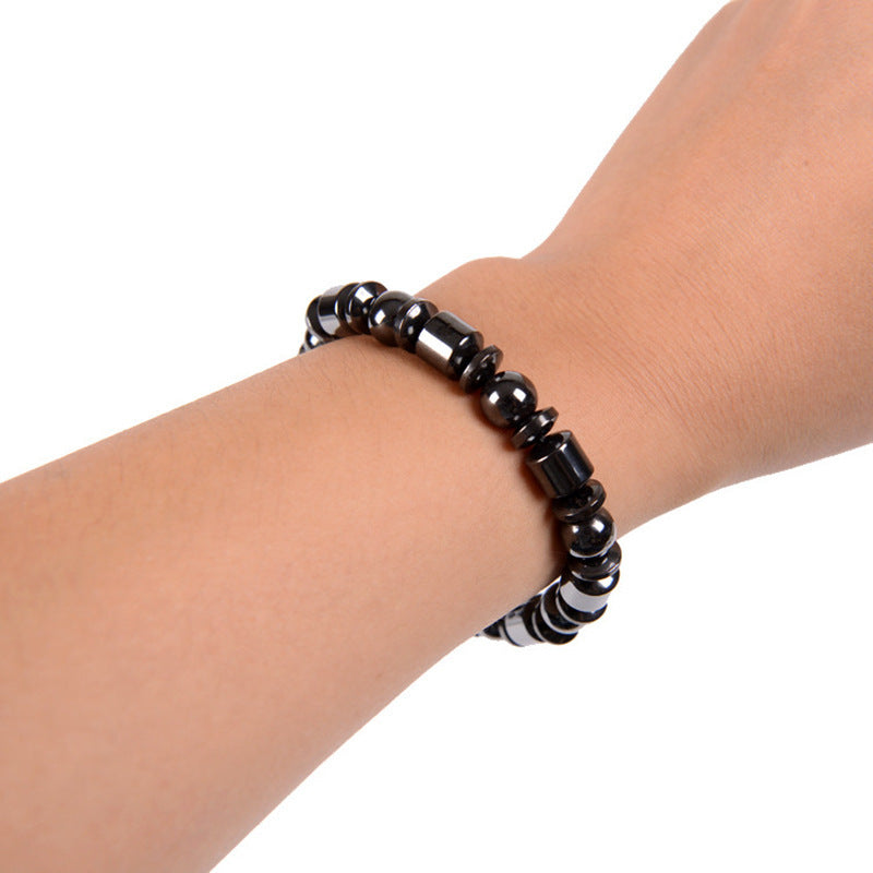 Black beaded bracelet on a wrist against a white background