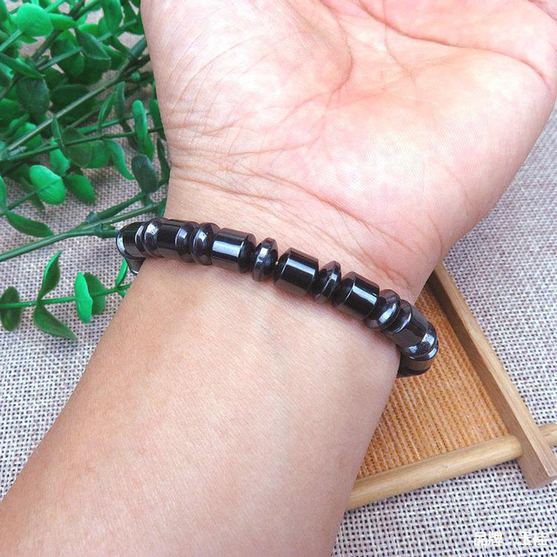 Black beaded bracelet on a wrist with a light background