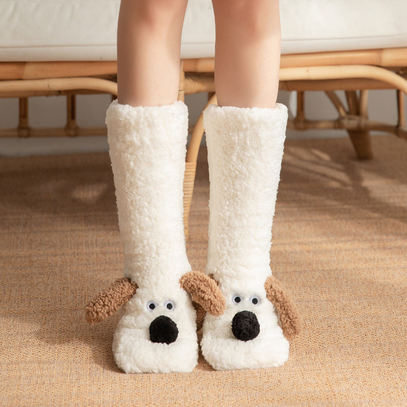 White dog-themed slippers worn by a person sitting on a woven chair.