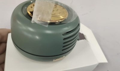 Green and gold circular object on a white surface