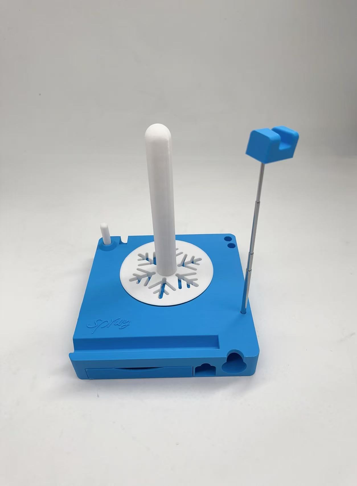 Blue plastic device with a white rod and blue handle on a light gray background