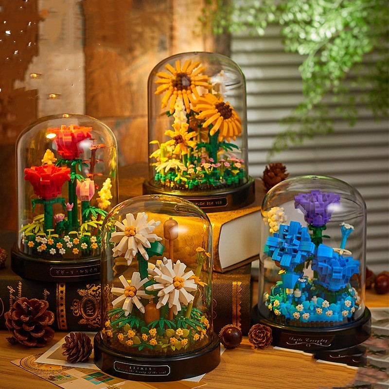 Four glass domes with colorful floral arrangements on a wooden surface.
