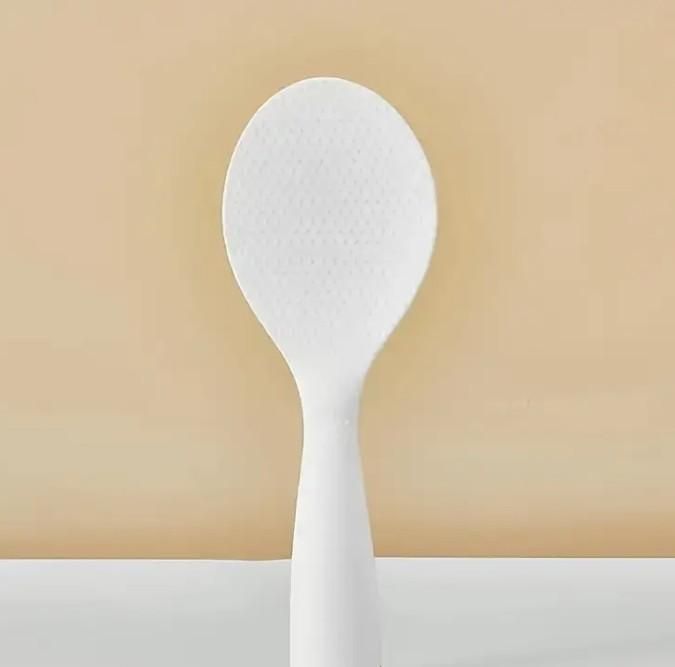 White spoon on a beige background