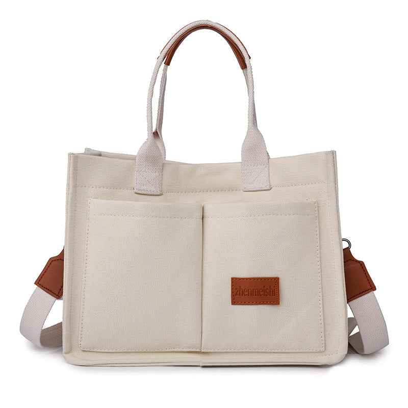 A collection of canvas tote shoulder bags in various colors, displayed in multiple pockets and with adjustable shoulder straps, showcased in a vertical format.