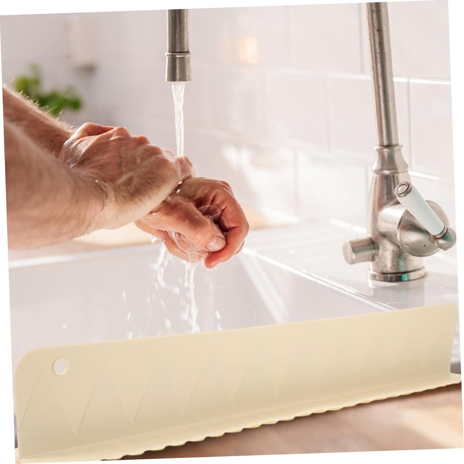 Person washing hands under a faucet with a kitchen sink in the background