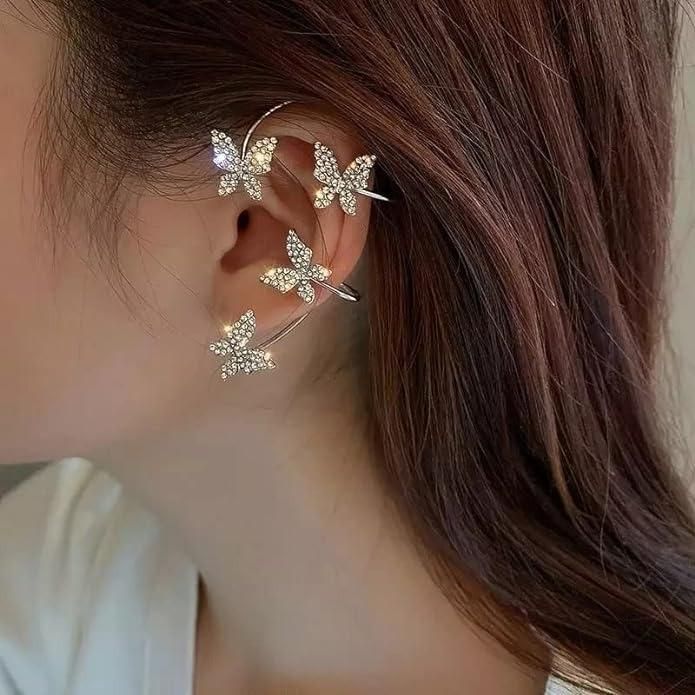 Butterfly-shaped earrings worn by a person with brown hair.