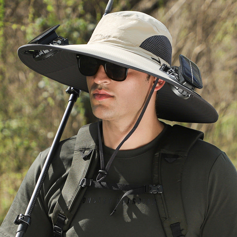 Person wearing a large sun hat with solar panels and sunglasses, standing outdoors.