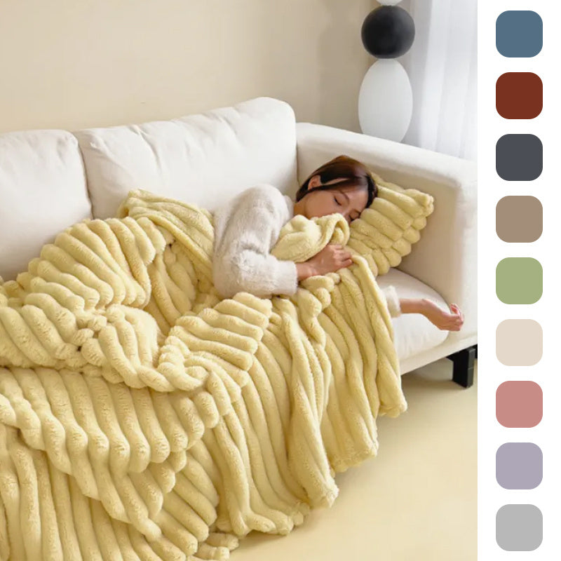 Person lying on a couch under a fluffy yellow blanket with color swatches on the side.
