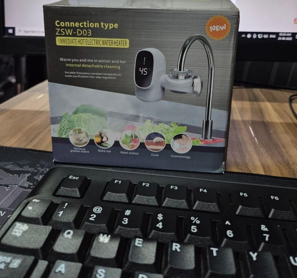 Hot electric water heater packaging on a desk with a keyboard in front