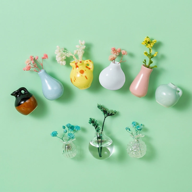 Collection of small vases with flowers on a light green background
