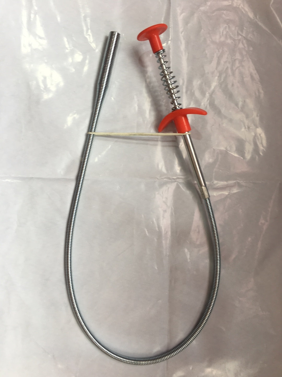 Metallic probe with red handle on a clear background